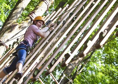 A guest climbs over a task in the climbing forest