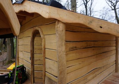 Rustic wooden hut made of robinia in a climbing forest