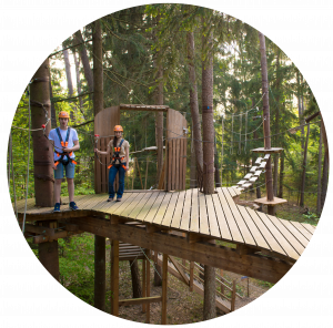 Zwei Gäste stehen auf einer großen Plattform am Start eines Parcours im Kletterwald